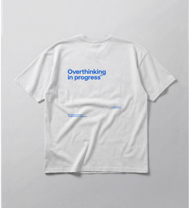White t-shirt with blue text 'Overthinking in progress' on a light gray background