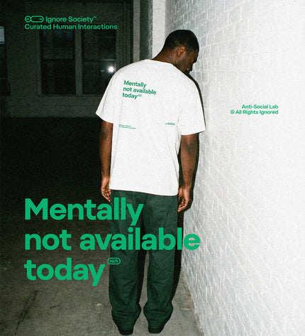 Person wearing a white t-shirt with 'Mentally not available today' text, leaning against a wall.
