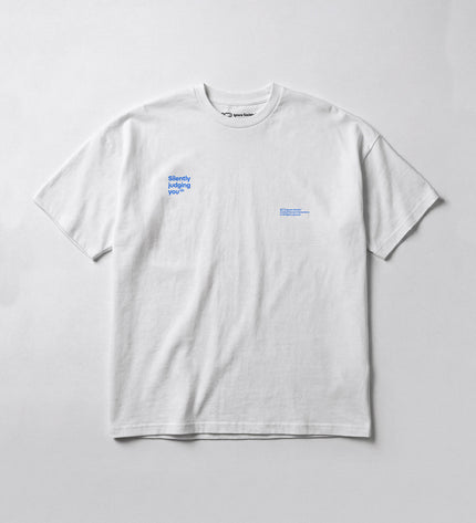 White t-shirt with small text design on a light gray background
