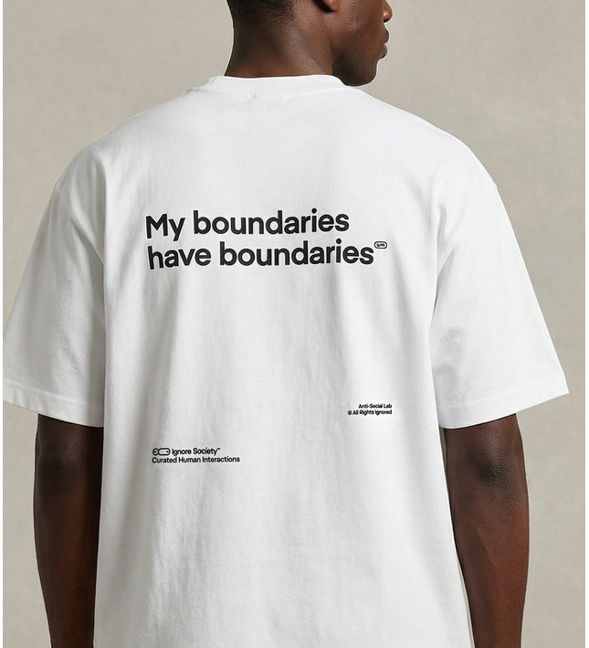 Person wearing a white t-shirt with text on the back, standing against a neutral background